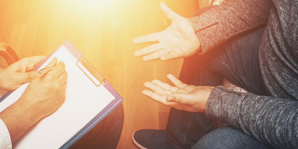 a person gestures while a therapist takes notes